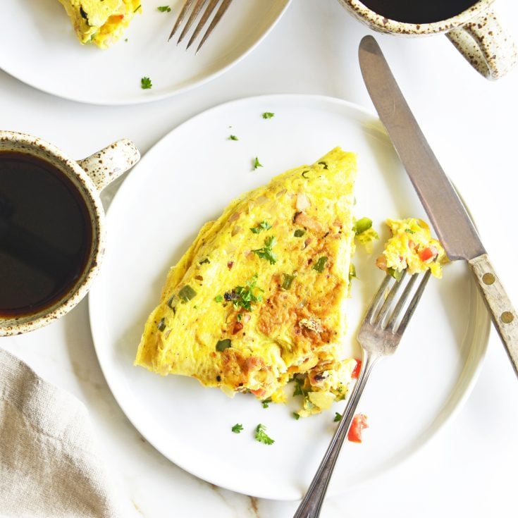 omelet on plate with cup of coffee