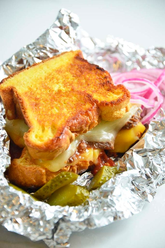 3 cheese keto grilled cheese sandwich on aluminum foil with pickles and red onions
