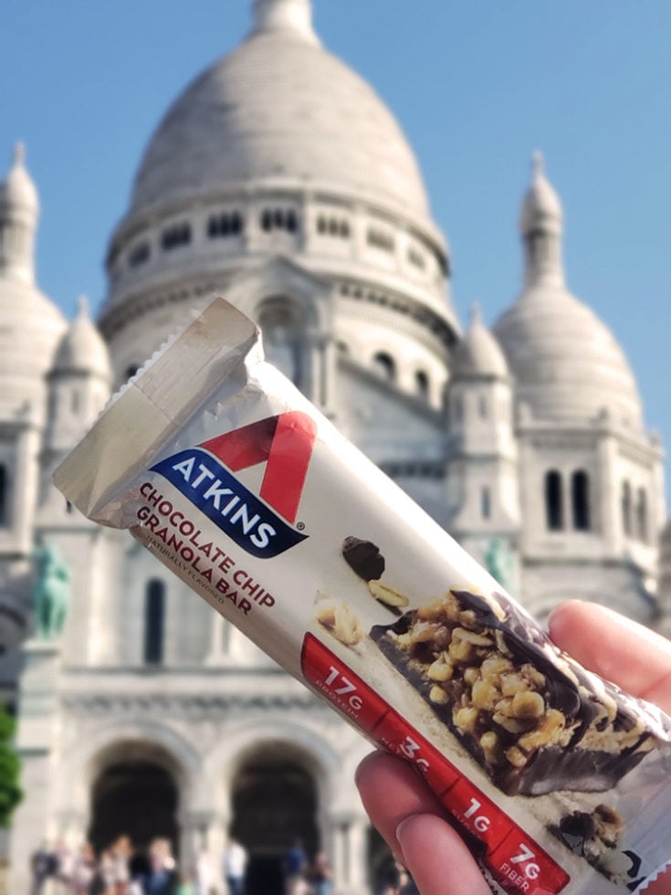 Atkins chocolate chip granola bar, a keto travel snack in front of acre couer in Paris