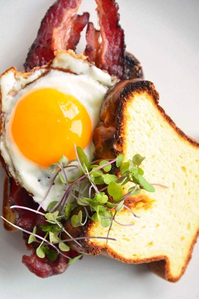 keto breakfast sandwich on a white plate topped with micro greens