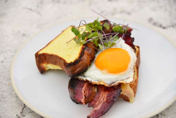 keto breakfast sandwich on a white plate topped with micro greens