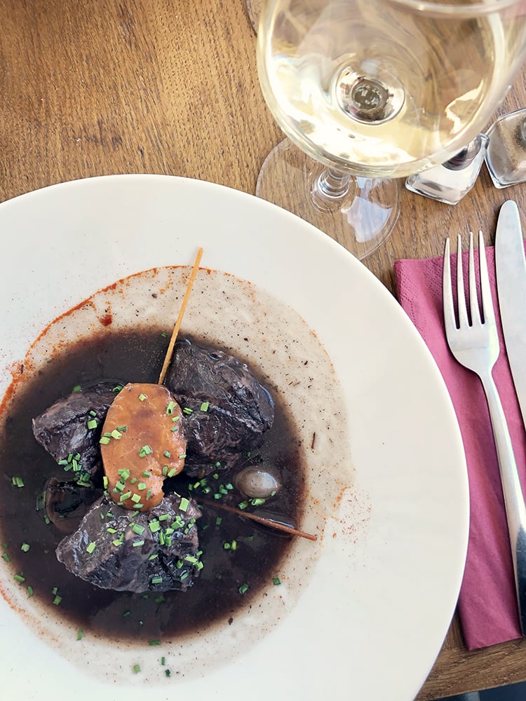 Beef Burgundy in White Bowl with Glass of Wine