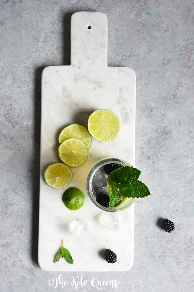 Blackberry Mojito Mocktail recipe in a clear glass garnished with mint, lime and blackberries