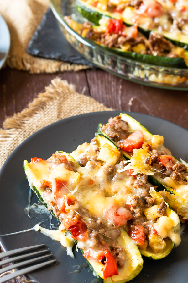 slow cooker BBQ brisket stuffed zucchini boats on a dark plate