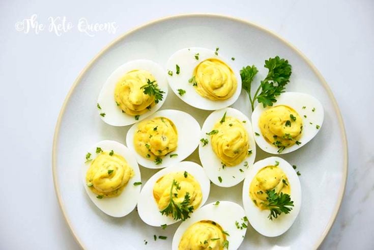 Horizontal Image of keto Instant Pot Deviled Eggs with Relish on a white plate with a white background