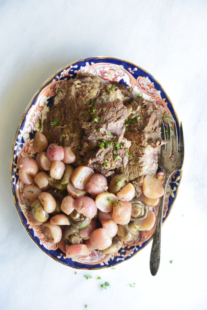 instant pot pot roast with radishes on a white background
