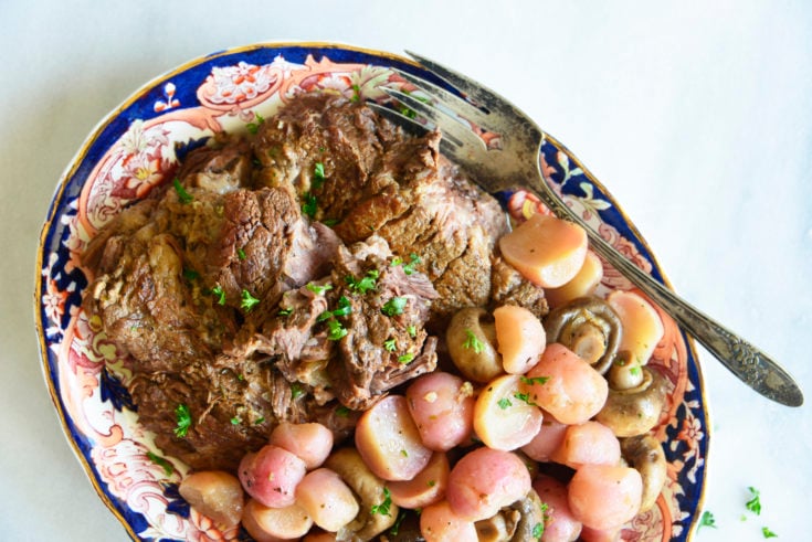 instant pot pot roast with radishes on a white background