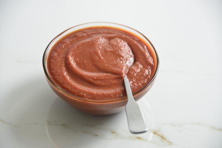 bowl of sugar free BBQ sauce i a clear bowl with a spoon