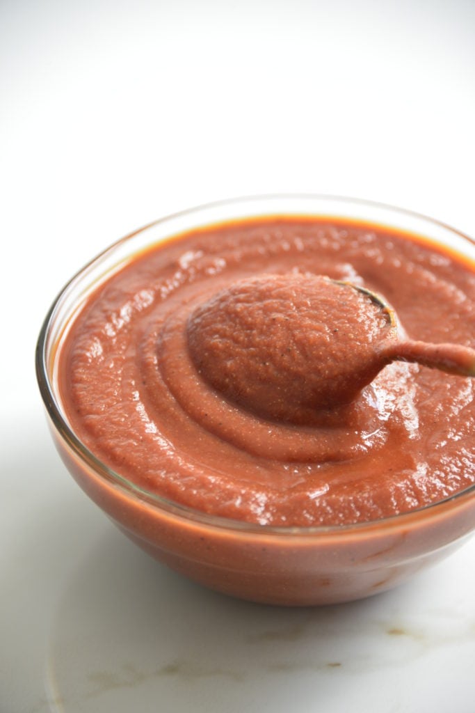 bowl of sugar free BBQ sauce i a clear bowl with a spoon