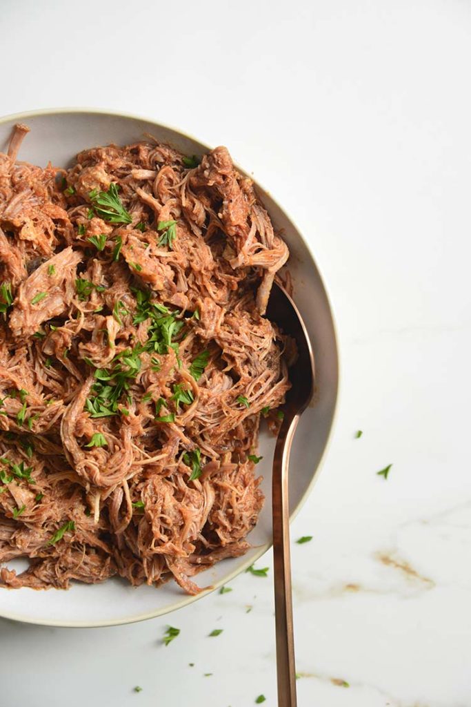 keto bbq pulled pork on a white bowl with parsley