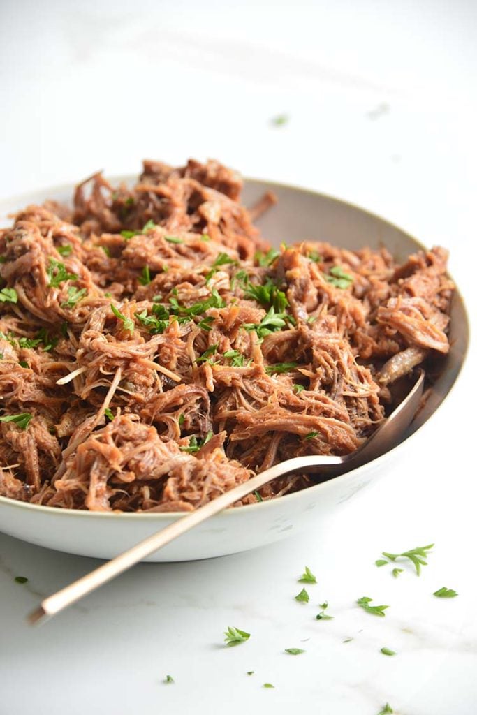 keto bbq pulled pork on a white bowl with parsley