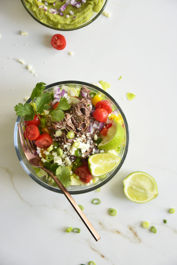 Shredded Beef Keto Taco Salad Recipe in a glass bowl on a white background with lime