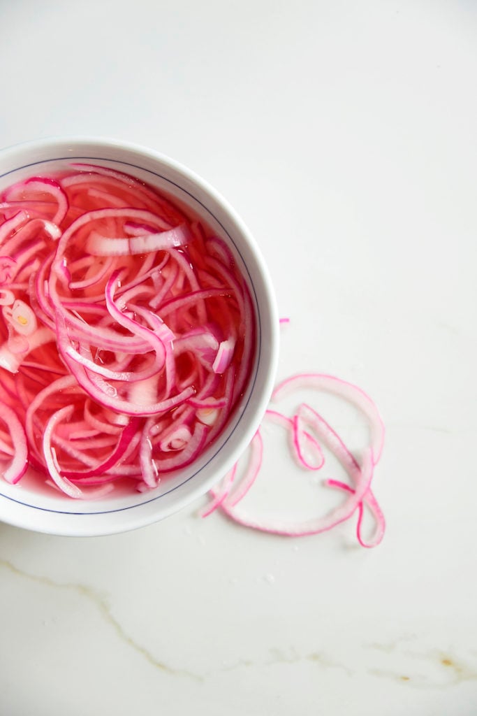 pickled red onion recipe made white sugar in a white bowl