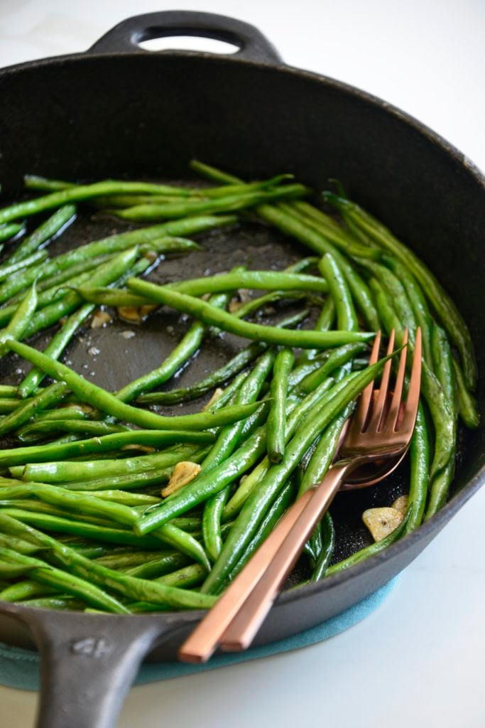 garlicky green beans cooked in a cast iron skillet