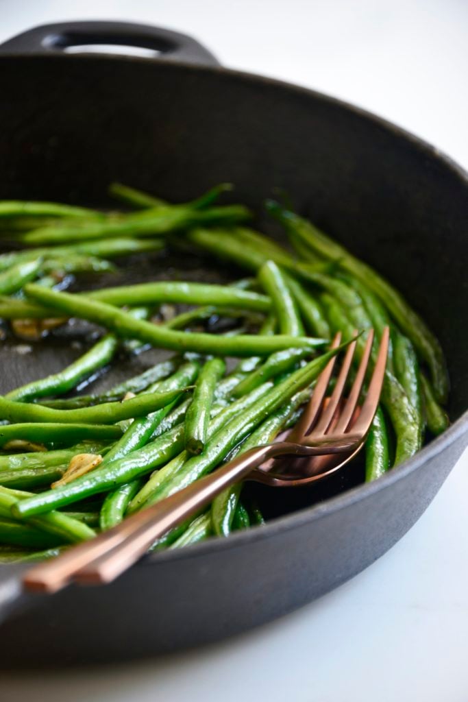garlicky green beans cooked in a cast iron skillet