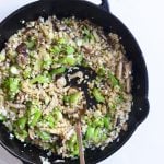 cauliflower fried rice in a cast iron skillet with a spoon