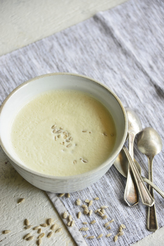 Instant pot cream of broccoli stalk soup in a white bowl with spoons