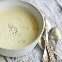 Instant pot cream of broccoli stalk soup in a white bowl with spoons