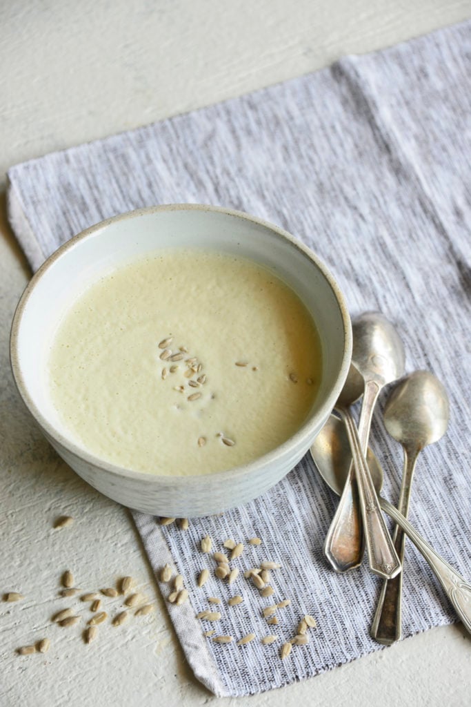 Instant pot cream of broccoli stalk soup in a white bowl with spoons