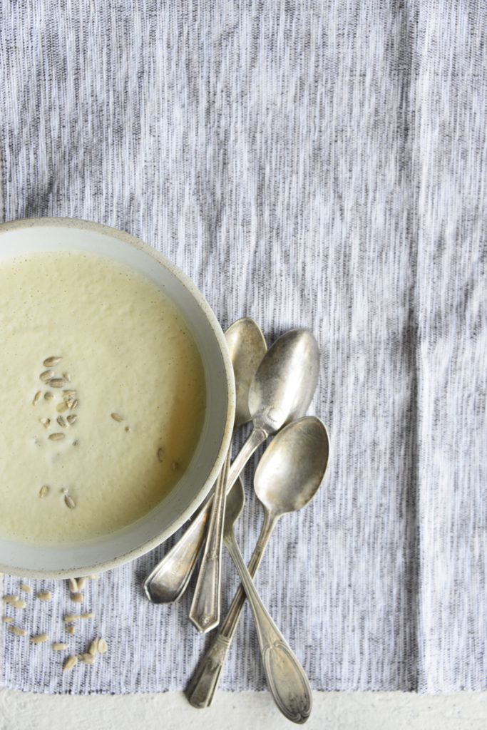 Instant pot cream of broccoli stalk soup in a white bowl with spoons