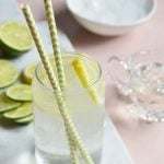 keto lemonade in a clear glass on a white slate with slices of lemon