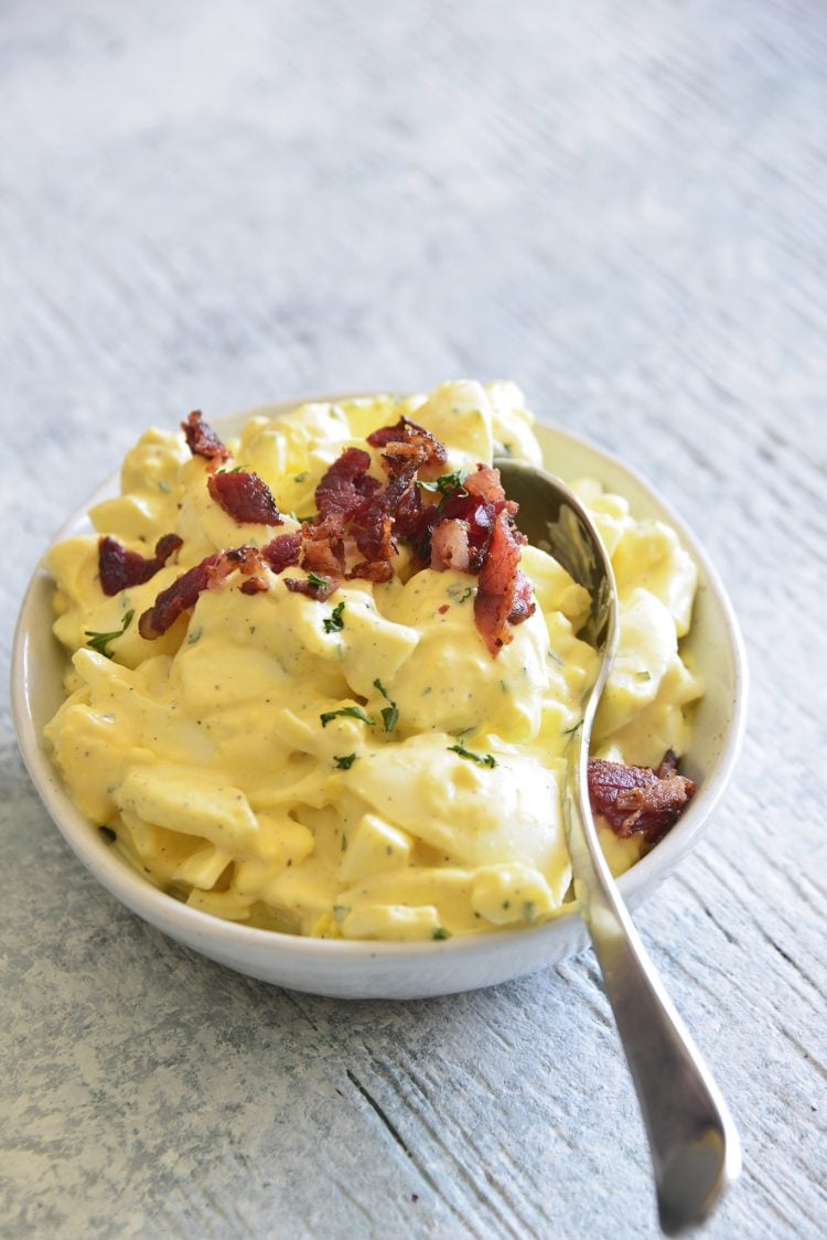 image of keto egg salad with bacon and a spoon on top