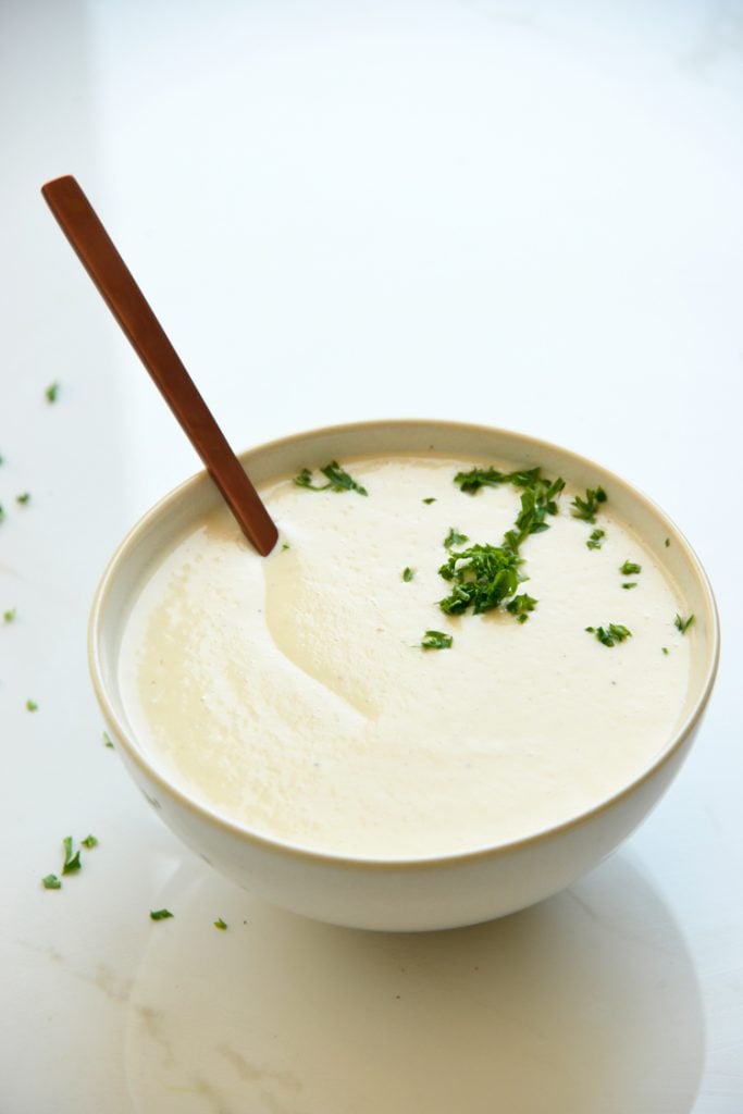 keto cauliflower soup on a white background with parsley