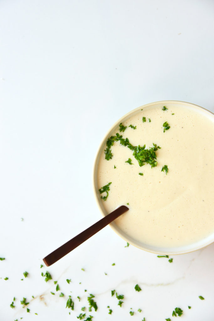 keto cauliflower soup on a white background with parsley