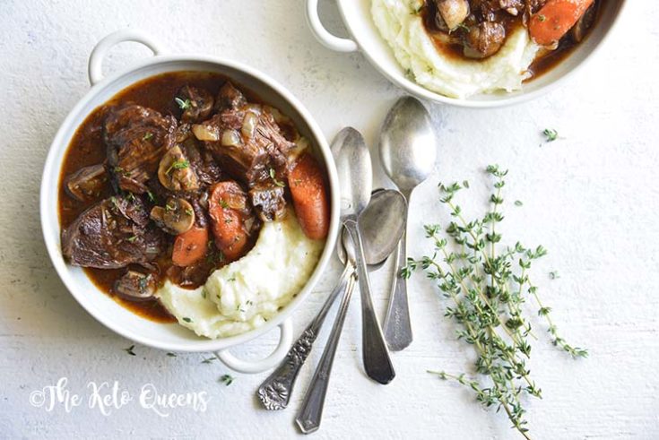 horizontal image of 2 low carb instant pot beef stew in a white bowl with 3 spoons and fresh herbs on a white background