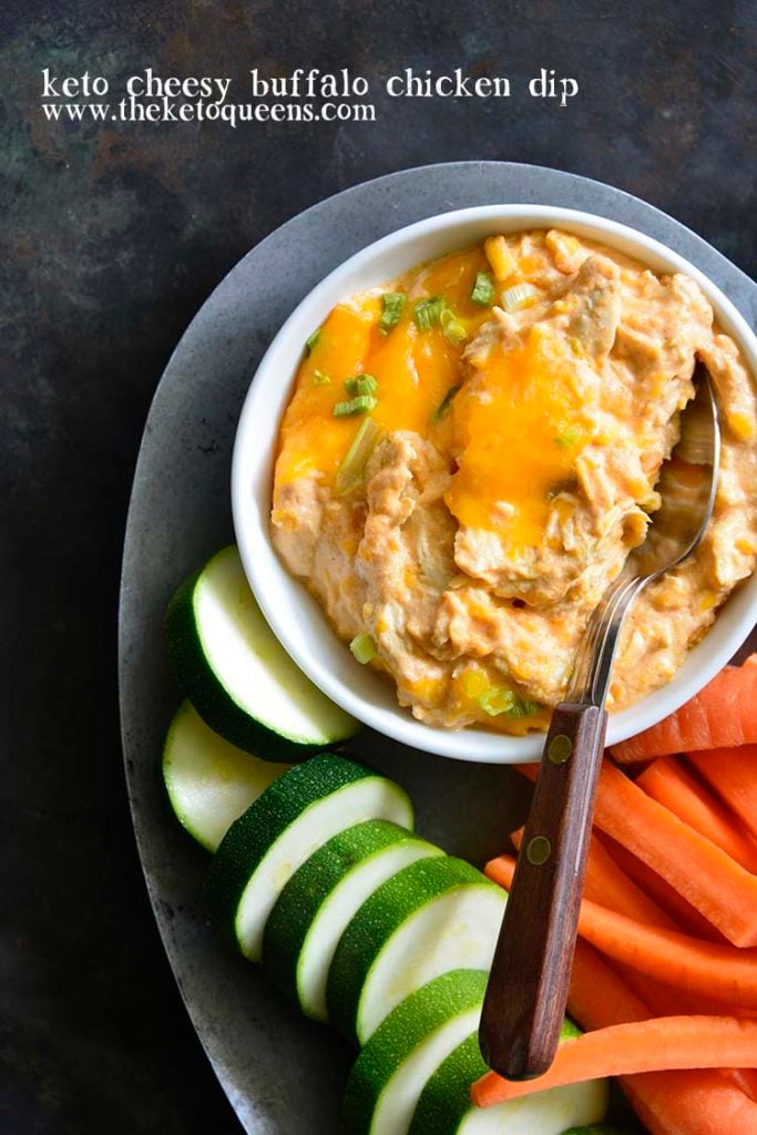 This Super Easy Buffalo Chicken Dip Recipe is the perfect appetizer for football Sundays, tailgating parties or to just have on hand as a keto snack. vertical image of buffalo chicken dip in a bowl with cucumber and carrots