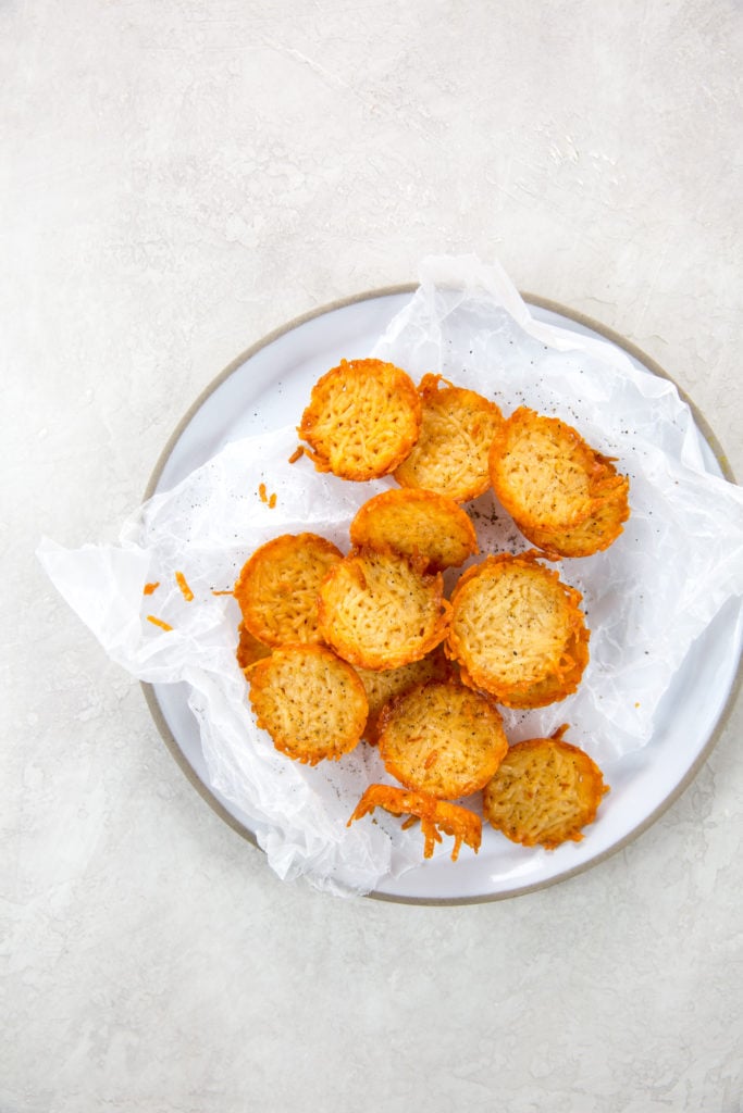 keto parmesan crisps on wax paper and plate