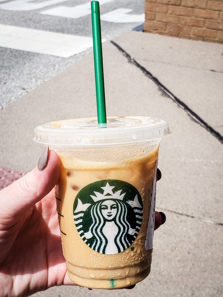 Tired of boring black coffee? Check out my top 5 Keto Starbucks Drinks to brighten your morning. picture of a person holding a Iced Coffee with Heavy Whipping Cream