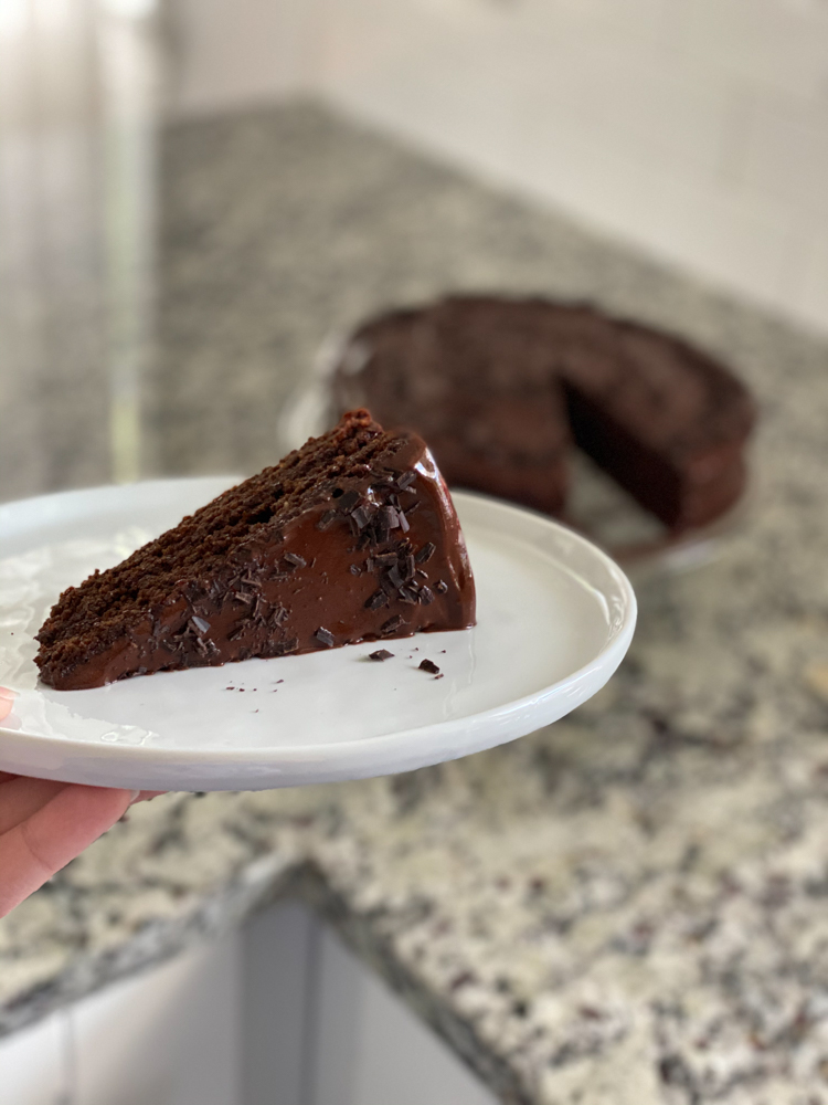 a slice of low carb flourless chocolate cake with frosting and sprinkles