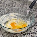eggs in a glass bowl with a whisk