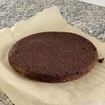 cooked low carb flourless chocolate cake cooling on parchment paper