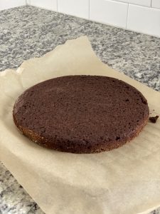 cooked low carb flourless chocolate cake cooling on parchment paper