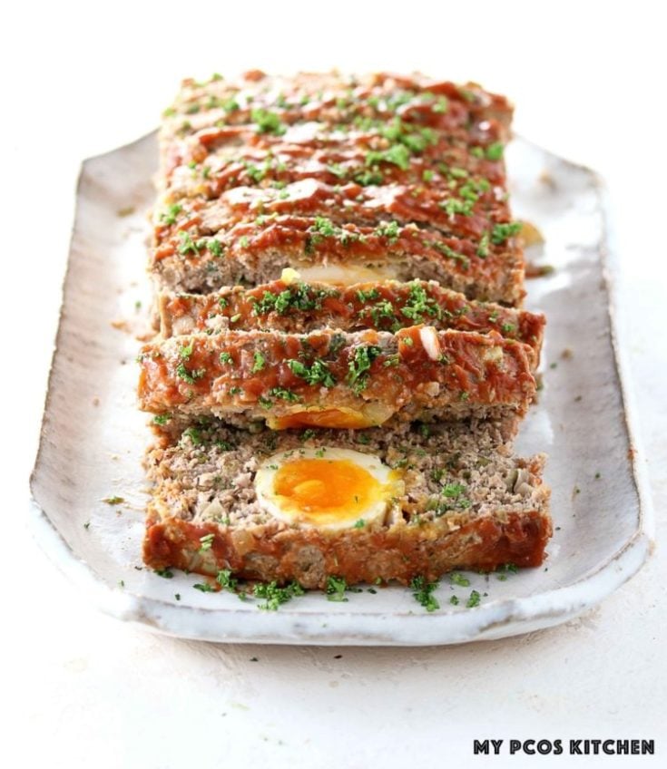 a vertical image of a keto meatloaf stuffed with leftover hard boiled eggs