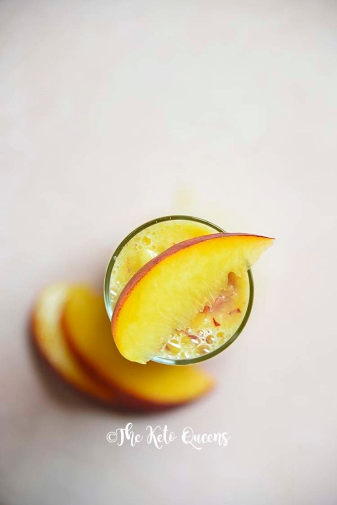 overhead shot of low carb peach bellini mocktail with peaches on top