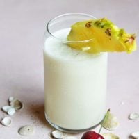 keto pina colada in a glass cup with pineapple and cherry