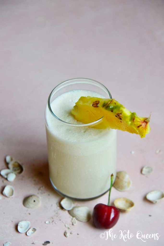 keto pina colada in a glass cup with pineapple and cherry