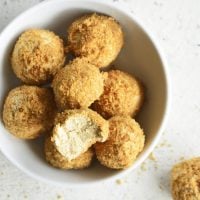 Keto Pumpkin Spice Cream Cheese Fat Bombs in a white bowl with a bite taken out