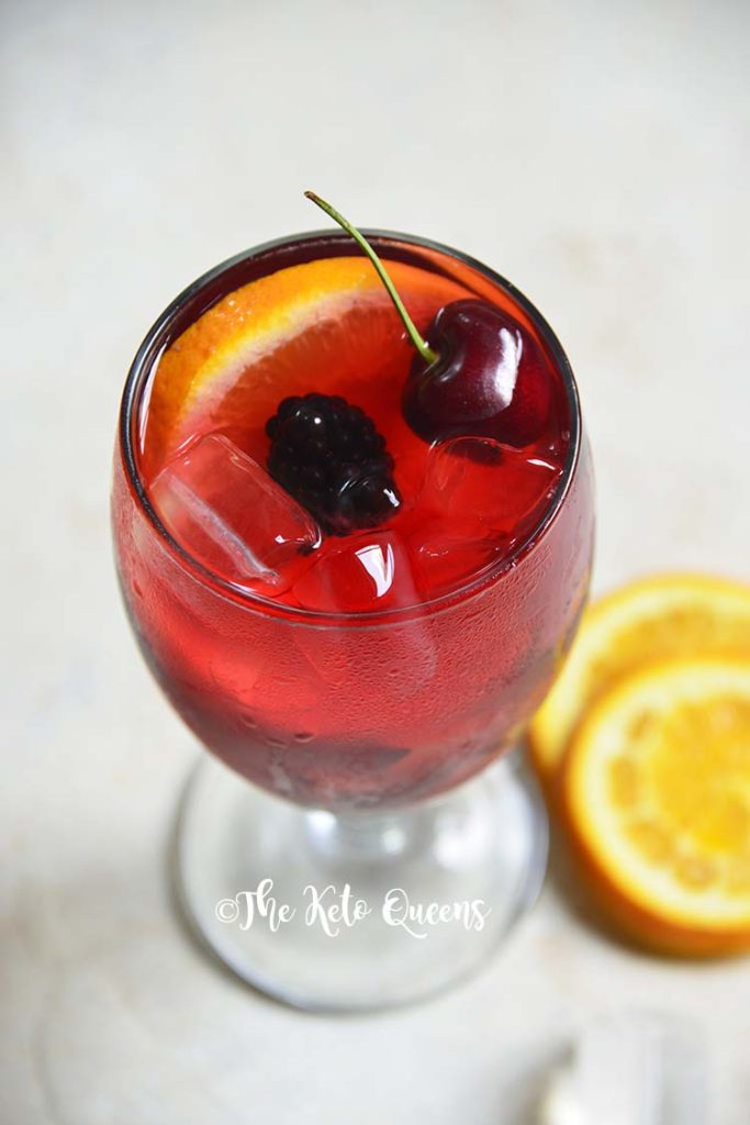 keto sangria mocktail recipe in a clear glass garnished with cherries and orange slices