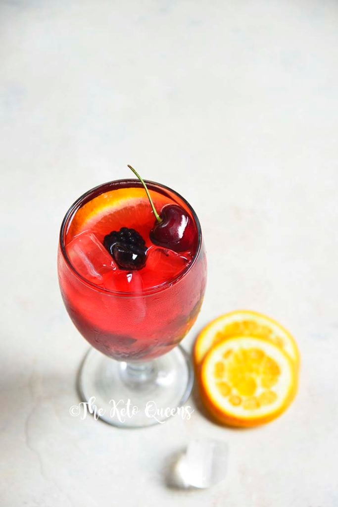 keto sangria mocktail recipe in a clear glass garnished with cherries and orange slices