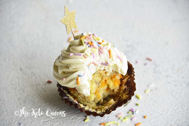horizontal image of a keto cupcake - vanilla cupcake with white chocolate buttercream frosting with sprinkles and a star with a bite taken out of it