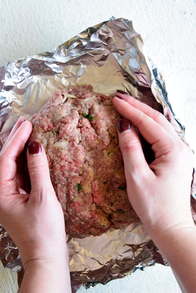 low carb meatloaf being formed into a loaf on aluminum foil