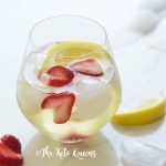 iced strawberry lemon tea in a seamless wine glass with lemon wedges