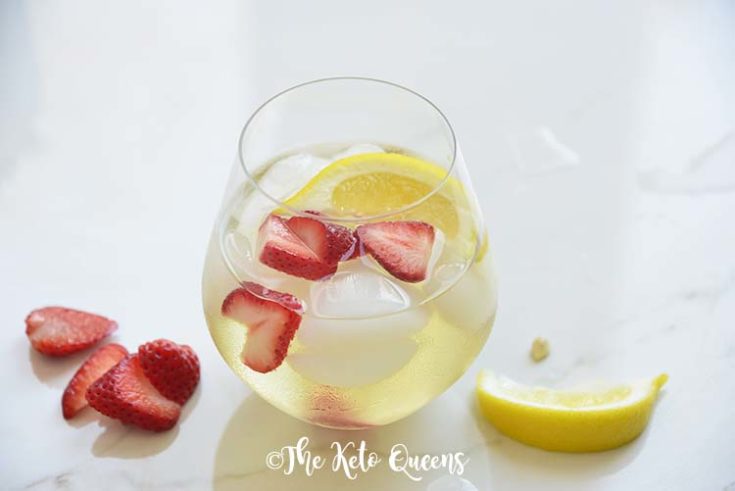 iced strawberry lemon tea in a seamless wine glass with lemon wedges