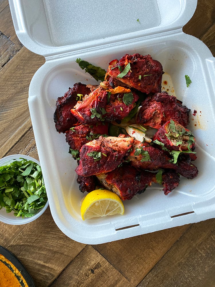 Tandoori Chicken in Takeout Box on Wooden Table