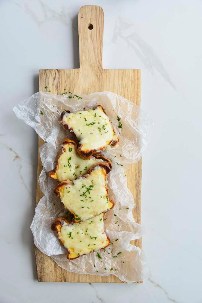 low carb Texas toast on a parchment paper and cutting board topped with parsley
