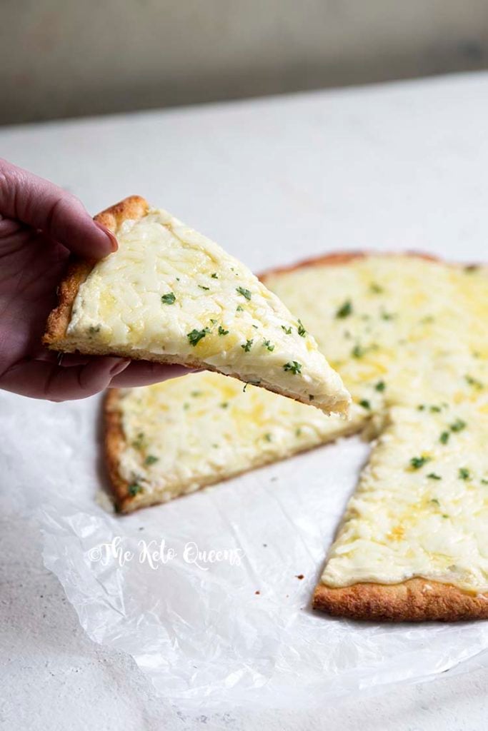 an image of a slice of keto 3 cheese white pizza on a fathead pizza crust